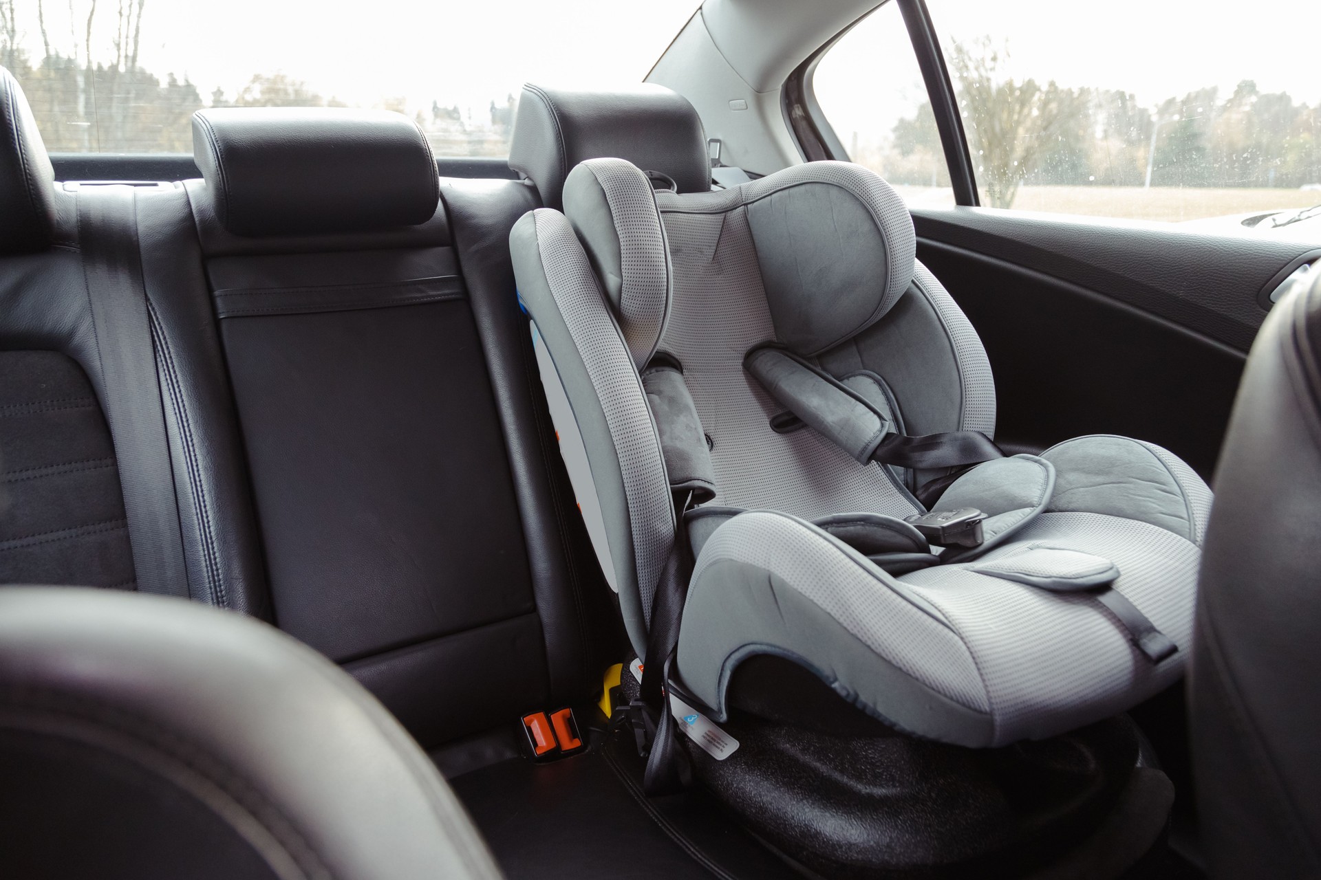 Child car seat for safety in the rear passenger seat of a car